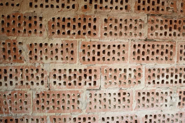 Big old red-orange brick wall background with little holes. Vint