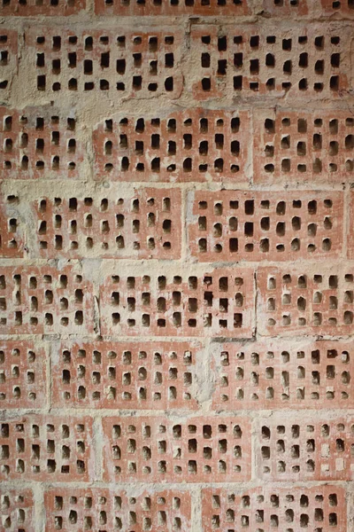 Big old red-orange brick wall background with little holes. Vint