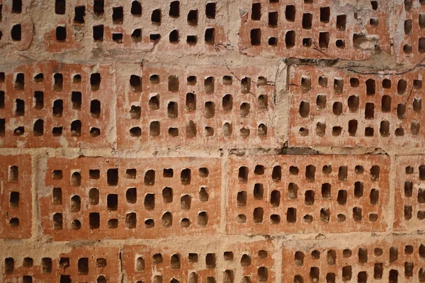 Big old red-orange brick wall background with little holes. Vint