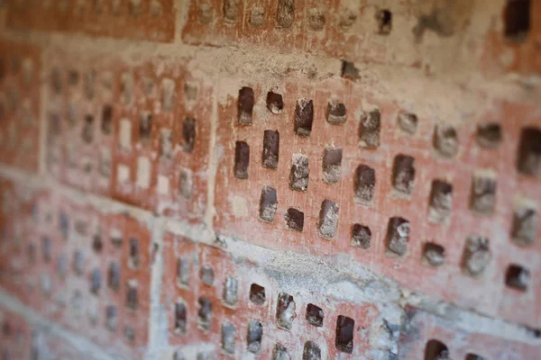 Big old red-orange brick wall background with little holes. Vint