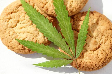 Esrar yapraklı kurabiyeler ve marihuana makrosu. Kenevir CBD kenevir otuyla pişirme kavramı. Gıda kullanımı için tıbbi marihuananın tedavisi, CBD kullanın
