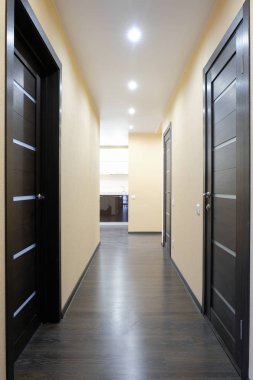Bir koridor üç ahşap kapı ile çekim