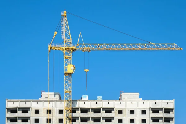 Las grúas de construcción sobre un fondo de cielo azul —  Fotos de Stock