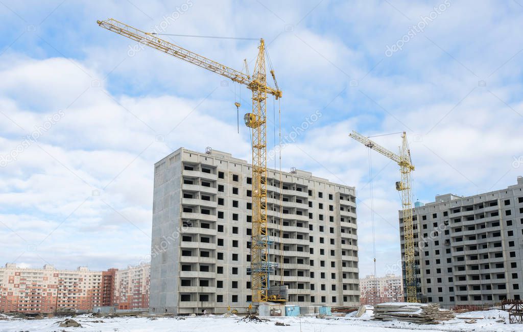 Construction cranes on a background of blue sky