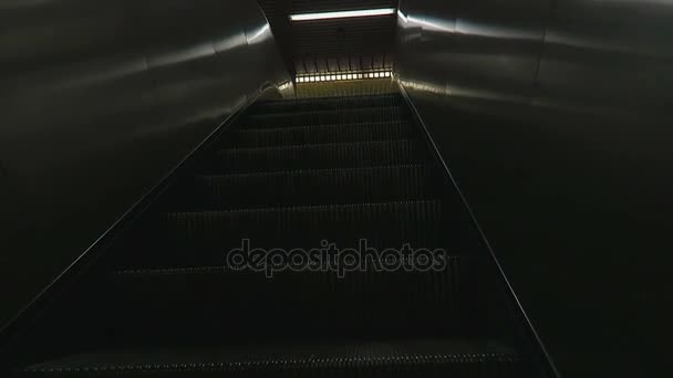 Monter dans l'escalier roulant du métro vers les portes de sortie ..