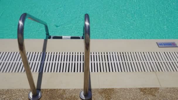 Outdoor swimming pool ladder with no diving sign on poolside. — Stock Video