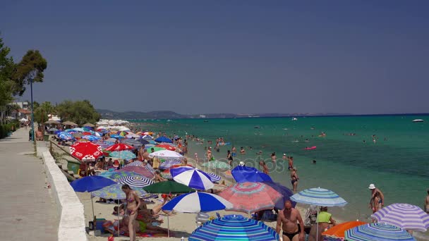 Chaniotis, Griekenland - juli 08 2017: Baders op het strand op een hete zomerdag. — Stockvideo