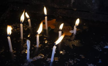 Karanlık su yüzeyinde erimiş mum yaktı beyaz mumlar.