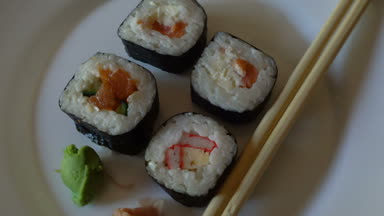 Beyaz bir tabak üzerinde dönen kadar yakın çeşitli Japon suşi rulo.