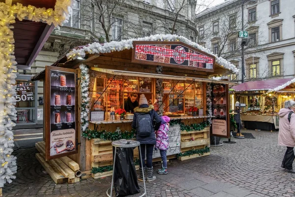 Budapeste, Hungria - 09 de dezembro de 2019: Kurtoskalacs - Chimney Cake pastry spit cake stand on Christmas Market . — Fotografia de Stock