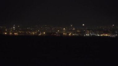Geceleri geniş yerleşim alanlarının üzerinde havai fişek gösterisi. Yeni Yıl Arifesi 01 Ocak 2020 'de Yunanistan' ın Selanik kentinde yeni yılın gelişi için havai fişekler kentin limanından görüldü..