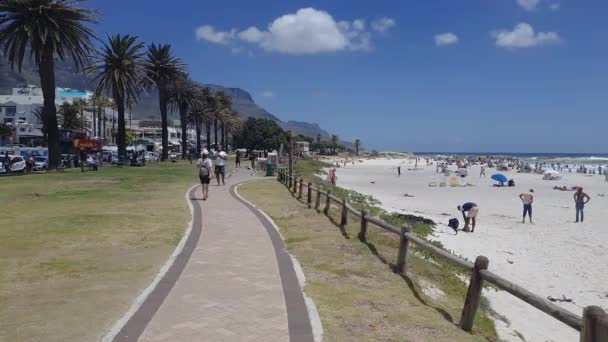 ケープタウン 南アフリカ 12月27 2019 キャンプベイビーチの晴れた日の景色 南アフリカ共和国の青い空の下 高層ビルが建ち並ぶ混雑したビーチの風景 — ストック動画