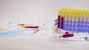 Mikrobiyoloji laboratuarı tıbbi biyolojik virüs konsepti. Tıbbi teçhizatla yapılan klinik testler. Kan tüpleri, şırıngalar ve koruyucu yüz maskesi gibi..