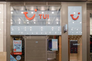 Manchester, Uk - 20 Şubat 2020: Tui seyahat acentesi şirket logosuyla mağaza girişini kapattı. Seyahat teklifleri ve posterleri olan bir turizm şirketinin vitrininin gece görüntüsü.