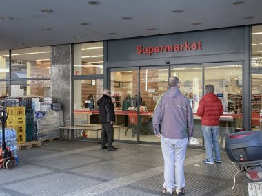 Selanik, Yunanistan - 16 Mart 2020: Coronavirüs tedbirleri iş ve günlük yaşamı etkiliyor. Yunanlılar, Yunan hükümetinin COVID-19 'u önleme kararı doğrultusunda süpermarket dışındaki mesafelerini koruyorlar.