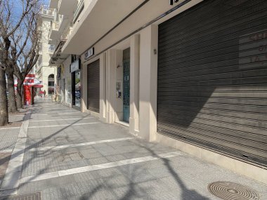 Selanik, Yunanistan - 18 Mart 2020: Coronavirüs tedbirleri iş ve günlük yaşamı etkiler. Boş sokaklar, kalabalık yok ve kapalı mağazalar, Yunan hükümetinin COVID-19 'un yayılmasını önleme kararı sonrasında.