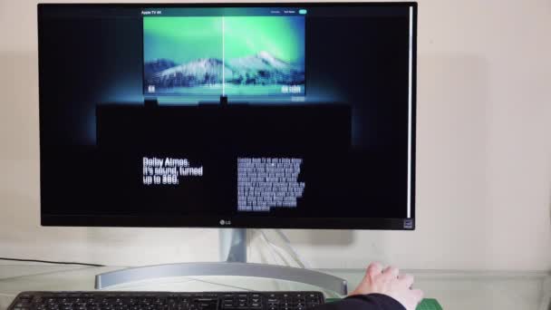 Mit dem Desktop-PC zum Durchsuchen von Apple TV plus Abonnementplattform. Männchen mit der Hand an der Maus am heimischen Computer blättert Webseite eines Online-Streaming-VoD-Anbieters