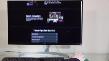 Netflix abonelik platformu sayfasına göz atmak için masaüstü bilgisayarı kullanılıyor. İnternet üzerinden yayın yapan bir VoD sağlayıcısının web sayfasında, ev bilgisayarındaki fare üzerinde elleri olan bir erkek.