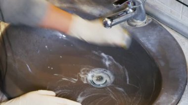 Yaygın enfeksiyon riskini azaltmak için dezenfektanla etkili bir temizlik banyosu. Koruyucu eldiven giyen, süngerli, deterjanlı bir kadın bakteriyi öldürmek için iyi bir teknik uyguluyor..