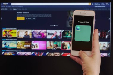 Selanik, Yunanistan - 21 Mart 2020: Amazon canlı yayın hizmeti VoD içerik sağlayıcısı kavramı. Ekrandan önce Amazon Prime Video çevrimiçi izleme uygulaması giriş sayfası olan bir cep telefonu tutun.