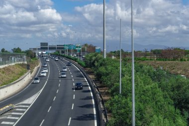 Roma, İtalya - 14 Eylül 2017: İtalyan karayolu trafiği gündüz görüşünü yükseltti. İtalyan başkentinin varoşlarındaki çok şeritli yolda çeşitli şehirlere giden yol işaretleri olan arabalar..