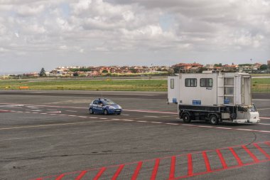 Roma, İtalya - 14 Eylül 2017: İtalyan Polisi, Ciampino havaalanı pistinde devriye geziyor. Eyalet Polisi, Polizia di Stato, Aeroporto G. B. Pastine 'in mavi aracı Aeorporti di Rome aracına eşlik ediyor.