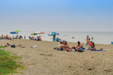 Yunanistan 'ın Neoi Epivates plajları yaz sezonu için açık. Selanik 'in varoşlarında deniz kenarında güneşli şemsiyelerle yıkanan, hükümet insanların uzak durmasını önerdikten sonra..