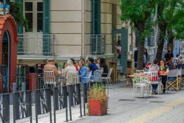 Selanik, Yunanistan - 25 Mayıs 2020: Yazın ilk günü için barlar açılıyor. Yunan hükümeti COVID-19 Coronavirus tedbirlerini gevşettikten sonra, şehir merkezindeki bar restoranlarında oturan kalabalık.
