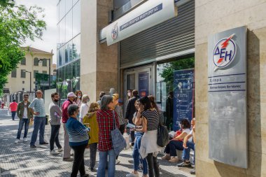 Selanik ve Yunanistan Coronavirüs ölçümleri günlük yaşamı etkiliyor. Yunanlılar, COVID-19 'u önleme kararı doğrultusunda DEI-Public Power Corporation' ın elektrik mağazası dışındaki mesafeyi koruyorlar.