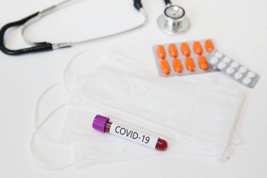 Tıbbi cihazlar, termometre, maskeler ve tabletlerle birlikte COVID-19 virüs testi.