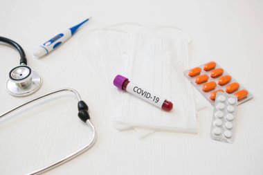 Tıbbi cihazlar, termometre, maskeler ve tabletlerle birlikte COVID-19 virüs testi.
