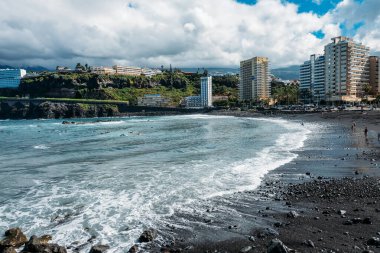 Atlantik Okyanusu üzerindeki şehrin manzarası. Tenerife, Puerto de la Cruz. Atlantik okyanusunda tropikal bir ada. Bir turist beldesi için fotoğraf. Gradyan ve tahıllı arkaplan rengi, ses efekti. 