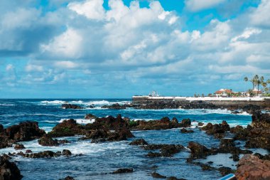 Tenerife adasının kıyısında. Tropikal bir adada turizm sezonu. İspanya 'da volkanik plajlar ve siyah kumlar. Atlantik okyanusundaki kayalar ve kayalar. Kanarya Adaları 'nda gezinti ve gezintiler
