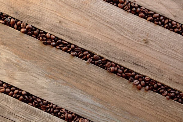 Coffee beans scattered between the slats. — Stock Photo, Image