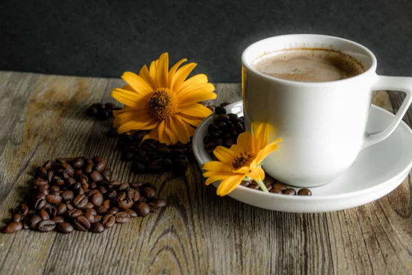 Tasse Kaffee mit gelben Blumen im Hintergrund. — Stockfoto