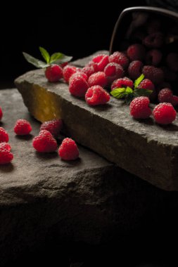 Olgun ahududu siyah arka plan üzerine bir fincan.