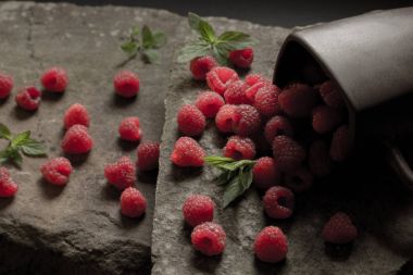 Olgun ahududu siyah arka plan üzerine bir fincan.