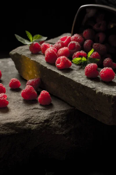 Olgun ahududu siyah arka plan üzerine bir fincan.