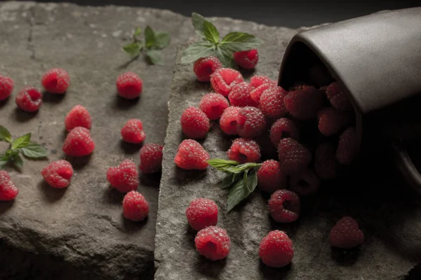 Olgun ahududu siyah arka plan üzerine bir fincan.