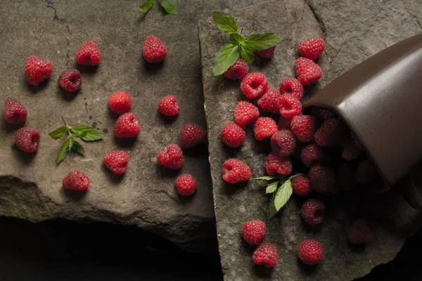 Olgun ahududu siyah arka plan üzerine bir fincan.