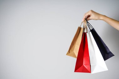 Renkli kağıt, kadın elinde gri bir arkaplan üzerinde Kraft eko paketleri, metin için yer.