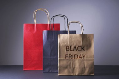 Kara Cuma konsepti, el işi siyah, kırmızı, kahverengi paketler, gri arka planda..