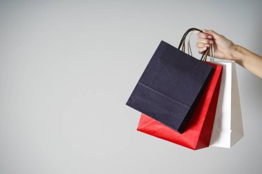 Kara Cuma konsepti. Renkli kağıt, Kraft eko paketleri kadın elinde gri bir arka planda, metin için yer var.