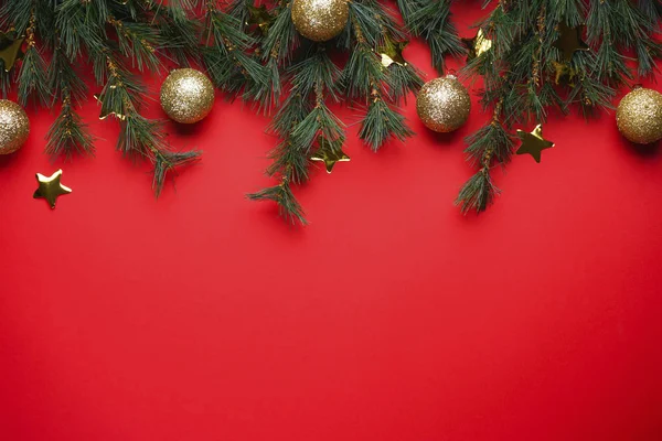 Noel konsepti. Kırmızı arka planda oyuncakları olan Noel Ağacı Dalları, metin için boşluk, düz uzanma.