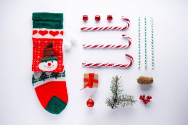 Noel kompozisyonu. Noel kartı konsepti çorap, şeker ve yeni yıl süslemeleri beyaz arka planda oyuncaklar.