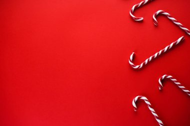 Noel kompozisyonu. Kırmızı arka planda Noel şekeri. Geleneksel Noel tatlıları. Düz yatış, metin için yer.