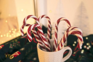 Beyaz seramik bardak, arkaplanda Noel tatlılığı var. Noel kompozisyonu.