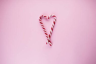 Pembe arka planda şekerlerden yapılmış bir kalp. Düz yatıyordu.