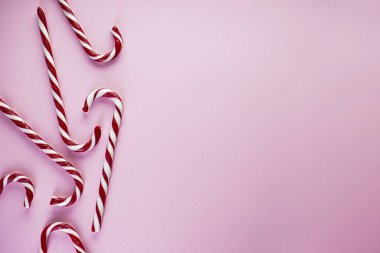 Noel kompozisyonu. Pembe arka planda Noel şekeri. Düz yatış, metin için yer.