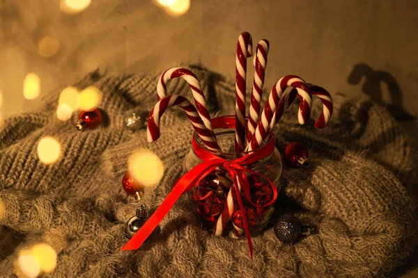 Kompozycja świąteczna ze słodyczami i dekoracjami świątecznymi na szarej kratce. — Zdjęcie stockowe